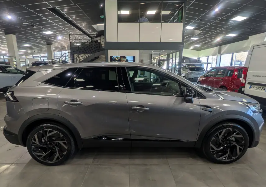 Vue de profil côté gauche du Renault SYMBIOZ E-TECH gris Cassiopé, soulignant ses jantes noires et lignes modernes.