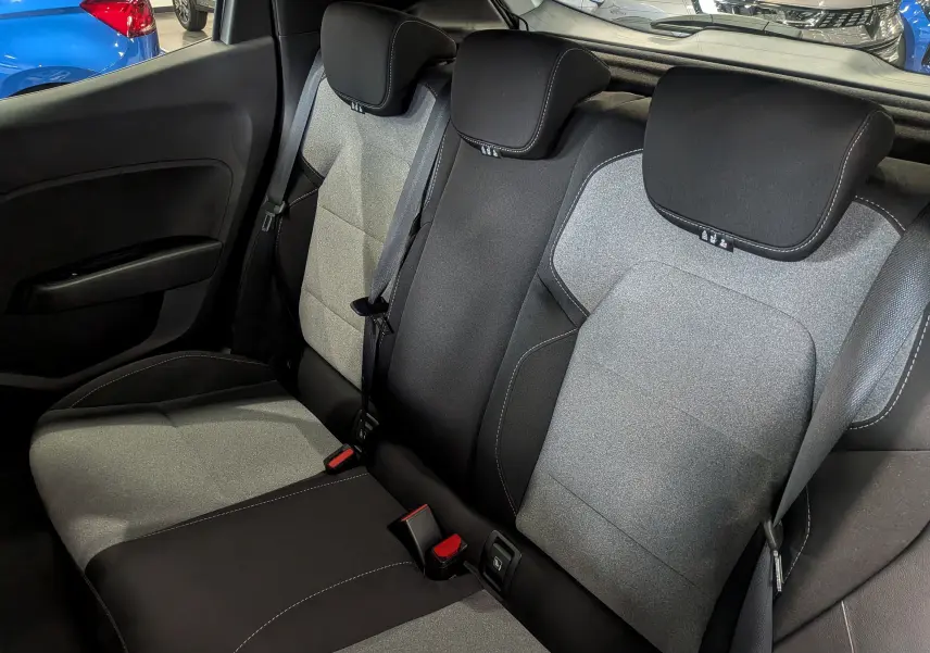 Vue intérieure arrière montrant les sièges tissu bicolores gris et noir de la Renault Clio V Blue dCi 100 CH Evolution.