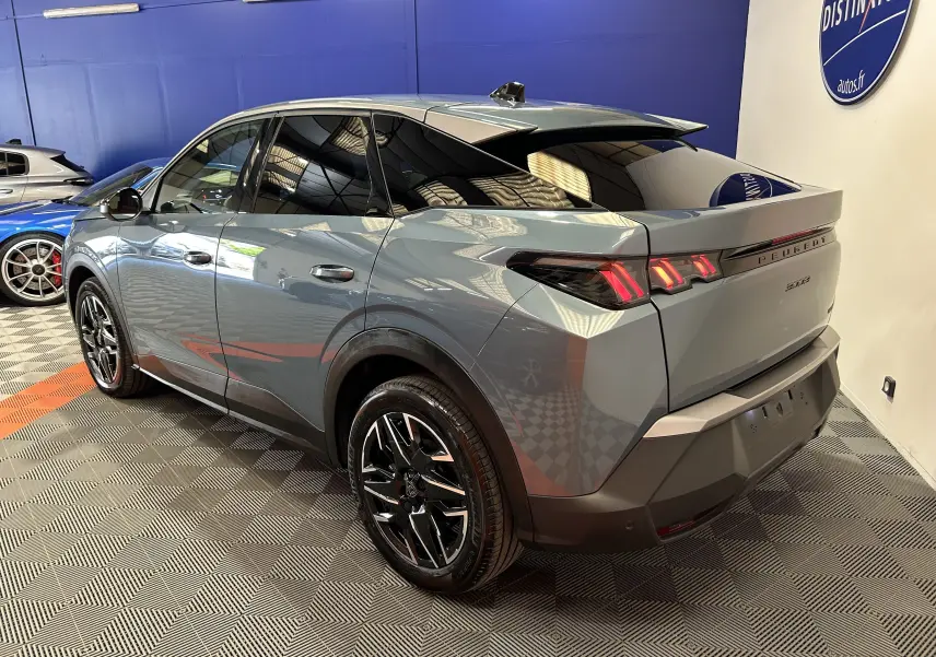 Vue 3/4 arrière droite du Peugeot 3008 Hybrid 2024 en Bleu Ingaro avec feux arrière LED et jantes noires brillantes.