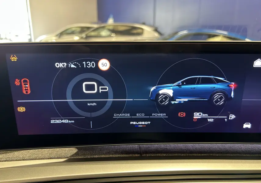 Affichage numérique du tableau de bord montrant un Peugeot 3008 bleu Ingaro en profil droit avec indicateurs de vitesse et autonomie.