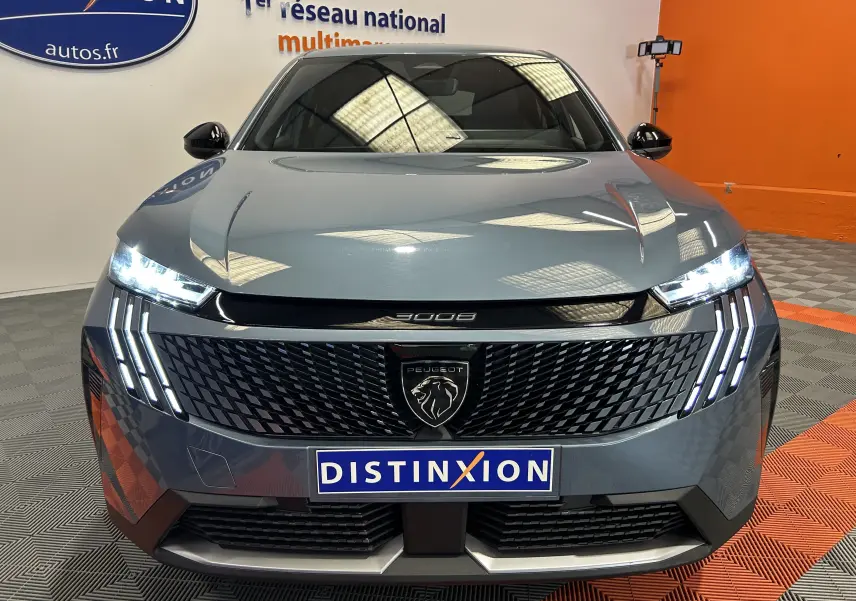Vue avant du Peugeot 3008 III Hybrid bleu Ingaro avec phares LED et calandre noire distinctive en showroom.