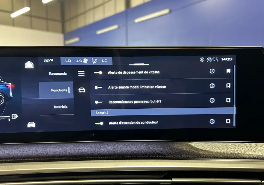 Écran tactile intérieur du Peugeot 3008 Hybrid 2024 affichant les réglages d'alerte de sécurité, avec tableau de bord en tissu gris.