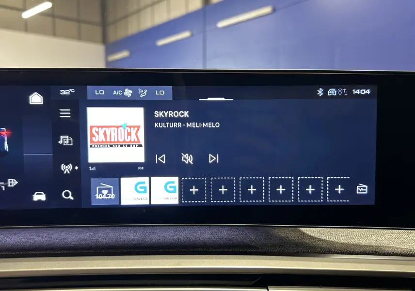 Écran tactile du tableau de bord du Peugeot 3008 Hybrid 2024 affichant l'interface radio avec station Skyrock.
