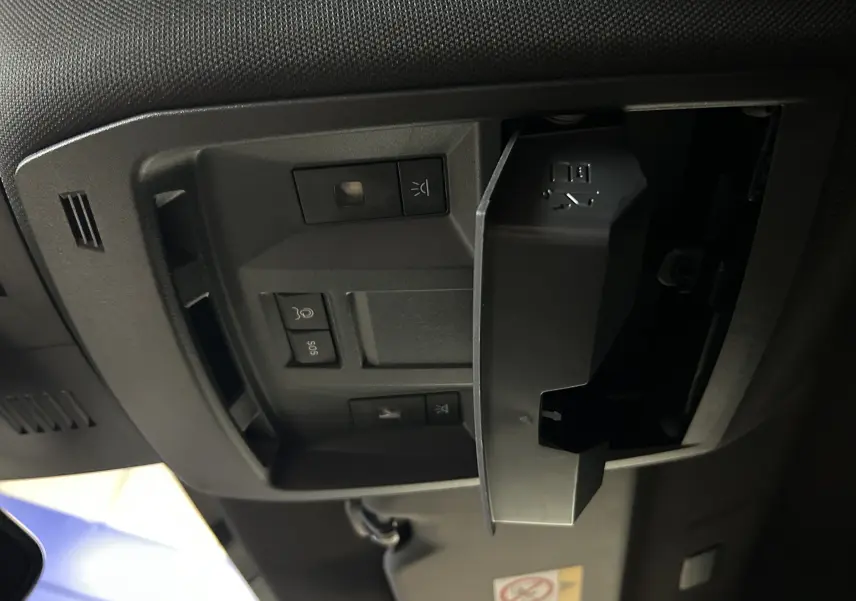 Gros plan sur le plafonnier noir avec commandes et compartiment ouvert dans l’habitacle d’un Peugeot 3008 bleu Ingaro.