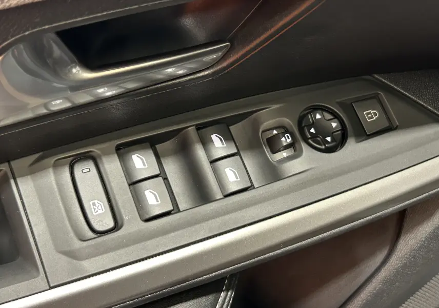 Gros plan sur les commandes des vitres et rétroviseurs côté gauche dans l’habitacle du Peugeot 3008 Hybrid 2024.