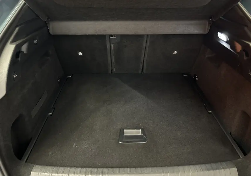 Vue intérieure du coffre spacieux et propre du Peugeot 3008 III Hybrid 136 e-DCS6 Allure en bleu Ingaro.