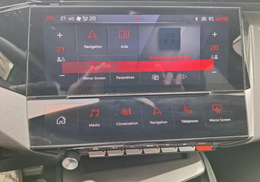 Vue rapprochée de l’écran tactile central du Peugeot 308 Hybrid 145 e-DCS6 GT gris, affichant les menus de navigation et climatisation.