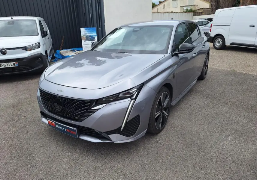 Peugeot 308 Hybrid gris vue 3/4 avant droit, avec calandre noire et jantes alliage 18 pouces.