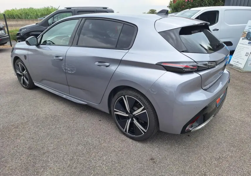 Peugeot 308 Hybrid gris vue 3/4 arrière droit, jantes alliage 18 pouces et feux arrière LED distinctifs.