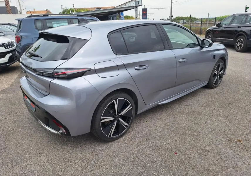 Vue 3/4 arrière droite d'une Peugeot 308 Hybrid 145 e-DCS6 GT gris métallisé avec jantes alliage 18 pouces.