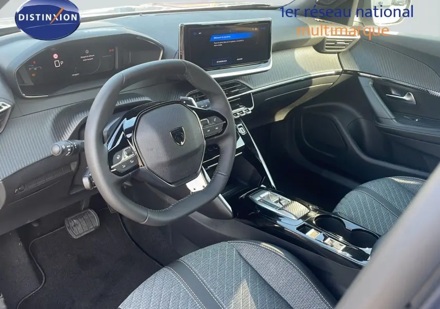 Intérieur avant droit du Peugeot 2008 Hybrid 136ch Allure 2025 avec volant compact et sellerie tissu gris.
