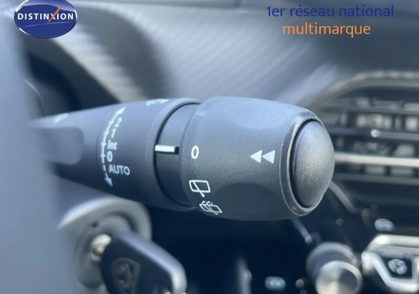 Gros plan sur la commande d'essuie-glace à gauche du volant dans l'habitacle du Peugeot 2008 gris Artense 2025.