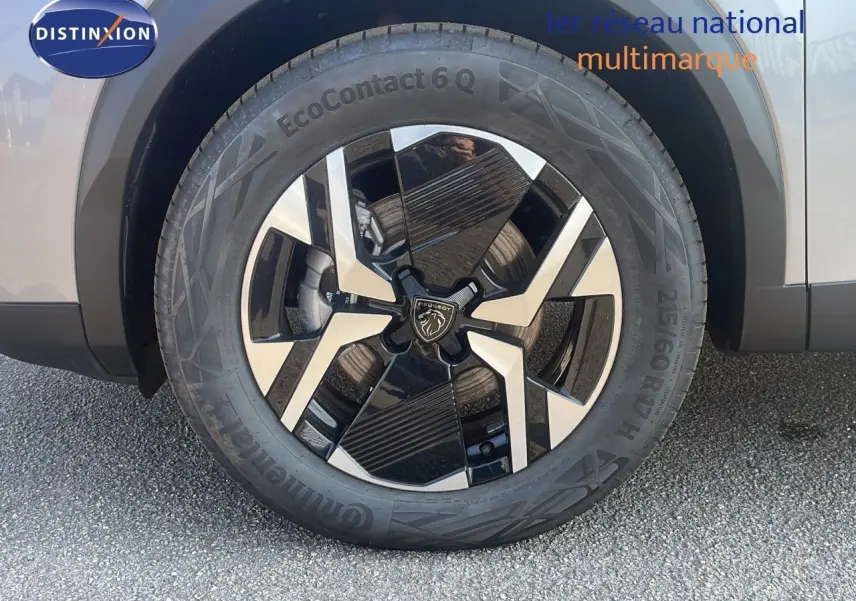 Gros plan sur la roue avant gauche du Peugeot 2008 gris Artense Metal avec jante alliage bicolore distinctive.