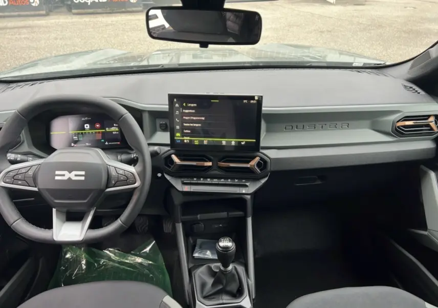 Intérieur du Dacia Duster 2025 kaki lichen, vue de face sur le tableau de bord et la console avec boîte manuelle.