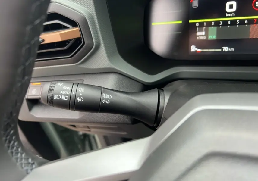Gros plan sur la commande des feux et clignotants à gauche du volant du Dacia Duster 2025 kaki lichen.