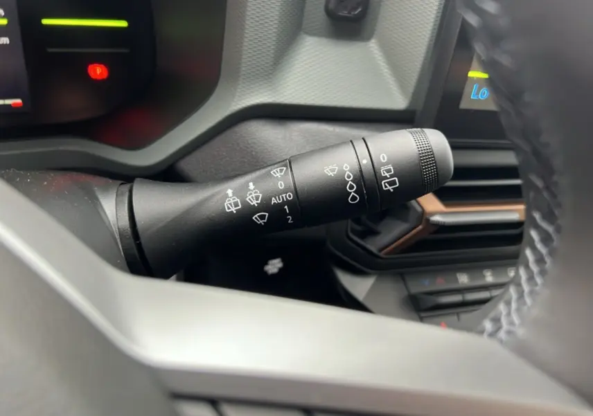 Gros plan sur la commande d'essuie-glace à gauche du volant du Dacia Duster 2025 kaki lichen, version TCE 130 4X2 Extreme Cold Tech.