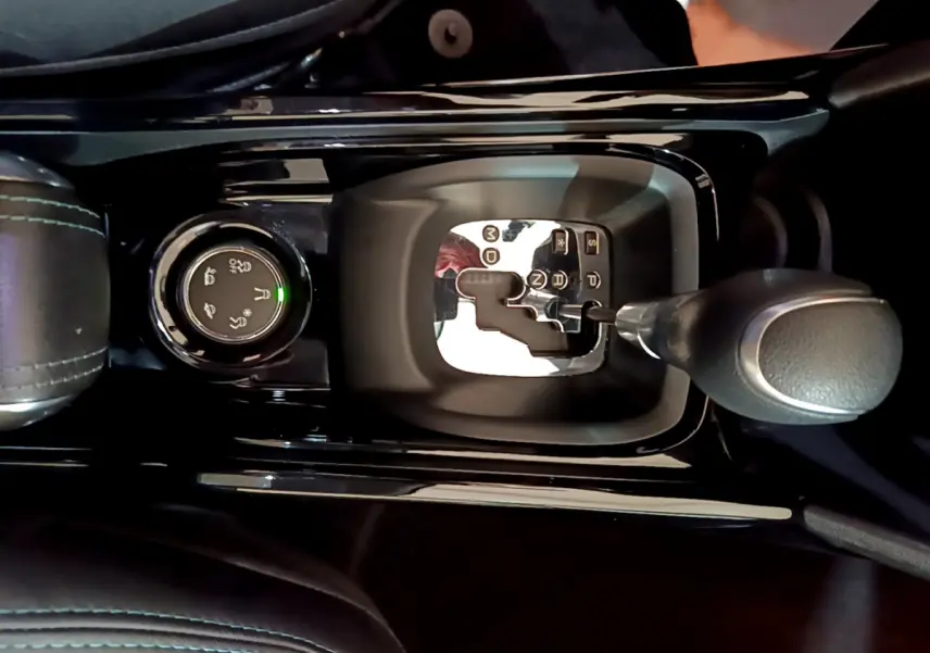 Gros plan sur la commande de boîte automatique et le sélecteur de modes de conduite du Peugeot 2008 gris foncé, intérieur noir.