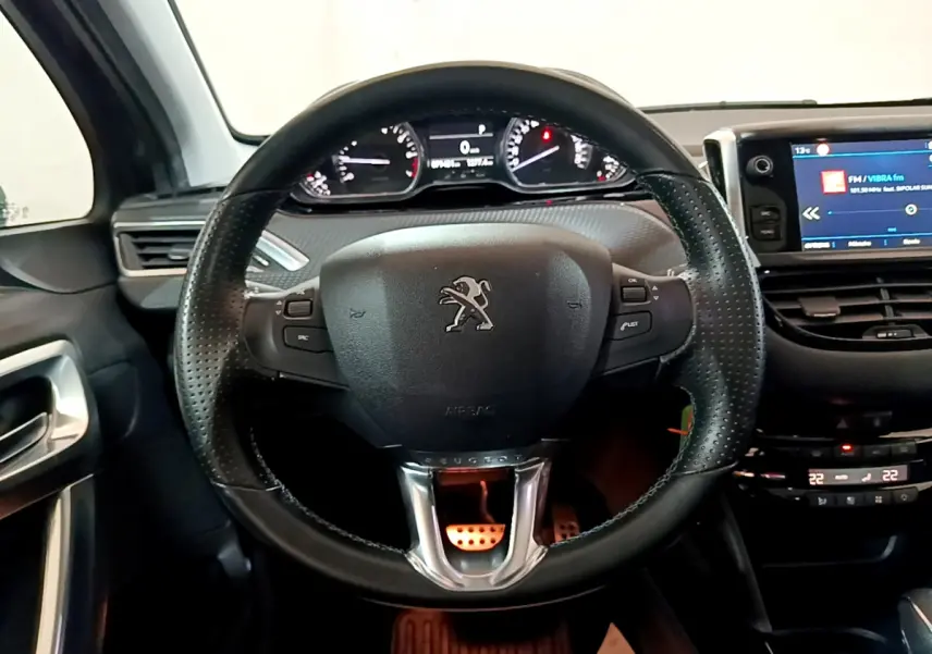 Vue intérieure centrée sur le volant cuir noir et le tableau de bord numérique du Peugeot 2008 gris foncé de 2019.