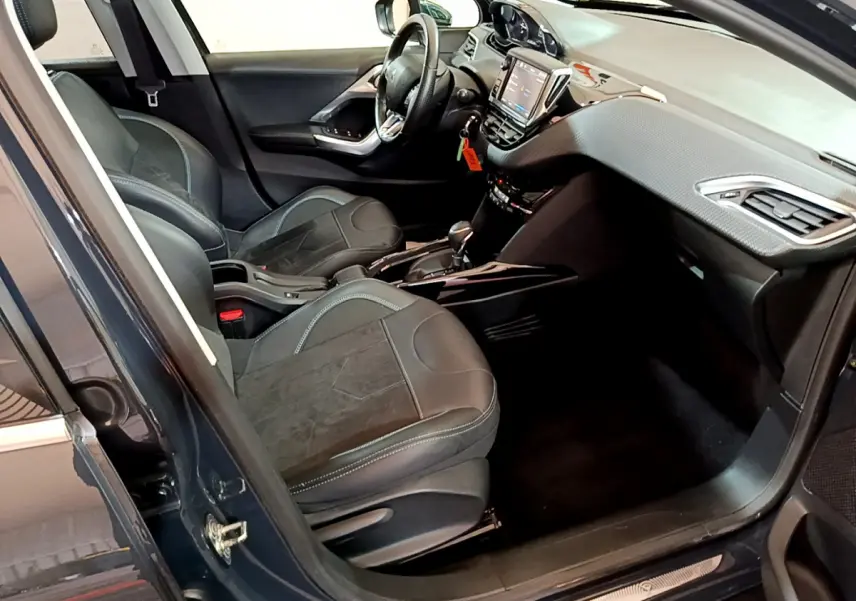 Intérieur avant droit du Peugeot 2008 gris foncé, avec sièges cuir et tableau de bord tactile visible.