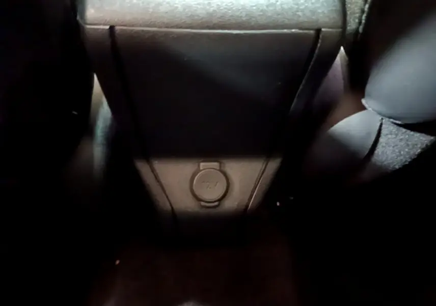 Prise 12V au bas de la console centrale arrière du Peugeot 2008 gris foncé, vue intérieure rapprochée.