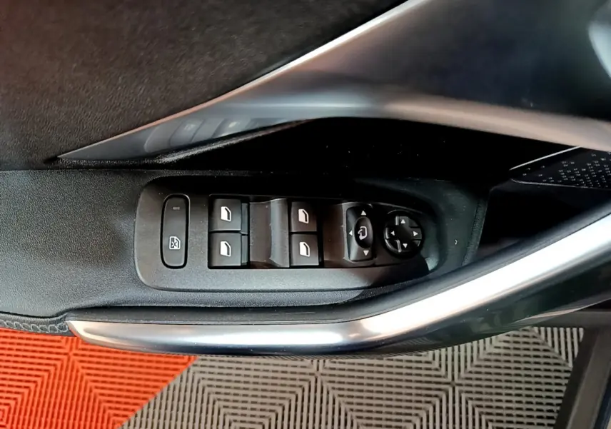Commande des vitres électriques et réglage des rétroviseurs sur la porte côté gauche d’un Peugeot 2008 gris foncé.