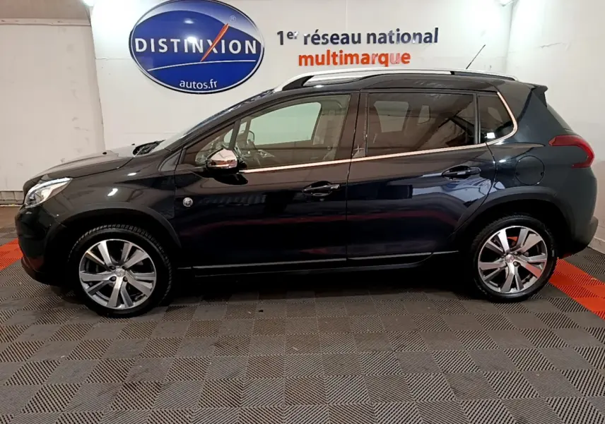 Peugeot 2008 gris foncé vue de profil côté gauche, avec jantes alliage et rétroviseurs chromés électriques.