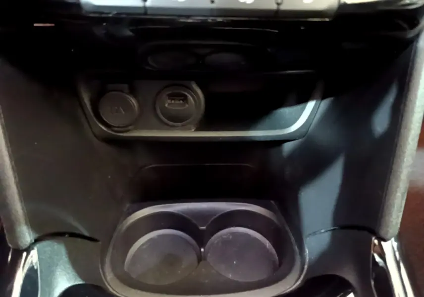 Prise 12V et port USB avec porte-gobelets au centre de la console d'une Peugeot 2008 Crossway gris foncé de 2019.