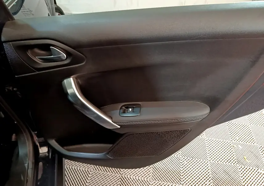 Vue rapprochée de la porte côté gauche noire du Peugeot 2008 Crossway 2019 avec poignée argentée et commande de vitre.