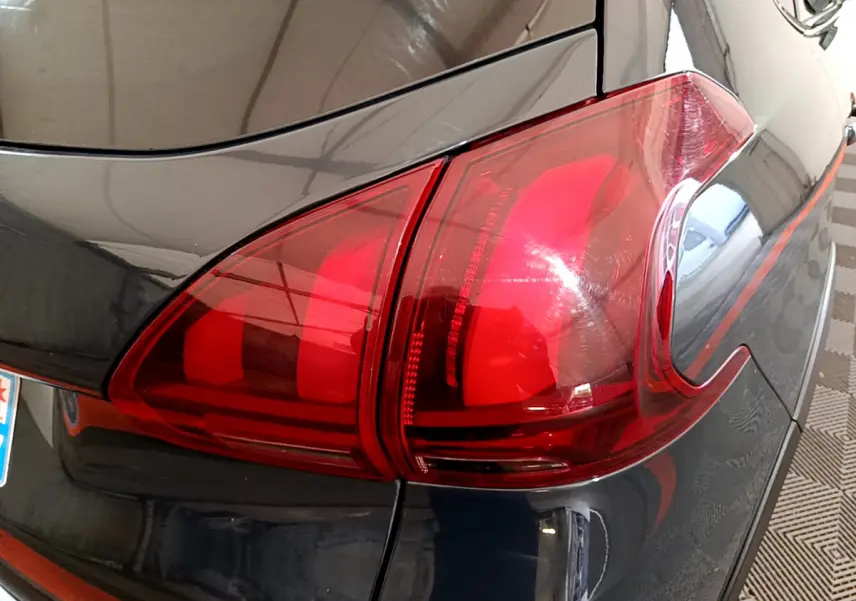 Gros plan sur le feu arrière droit rouge d'un Peugeot 2008 gris foncé, version Crossway 2019.