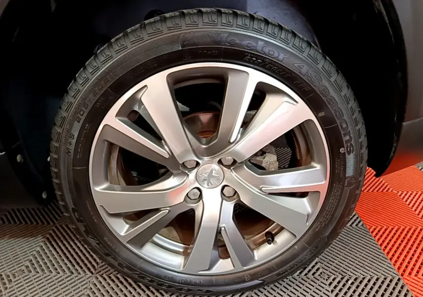 Gros plan sur la roue arrière droite du Peugeot 2008 gris foncé, montrant le pneu et l'arche de roue.