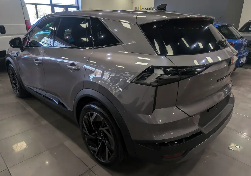 Vue 3/4 arrière droite du Renault SYMBIOZ gris Cassiopé avec jantes noires et vitres teintées en intérieur showroom.