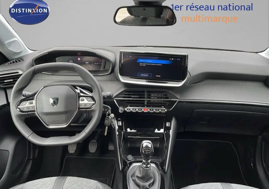 Intérieur de la Peugeot 208 2024 noir Perla Metal, vue frontale du tableau de bord avec boîte manuelle et écran tactile.