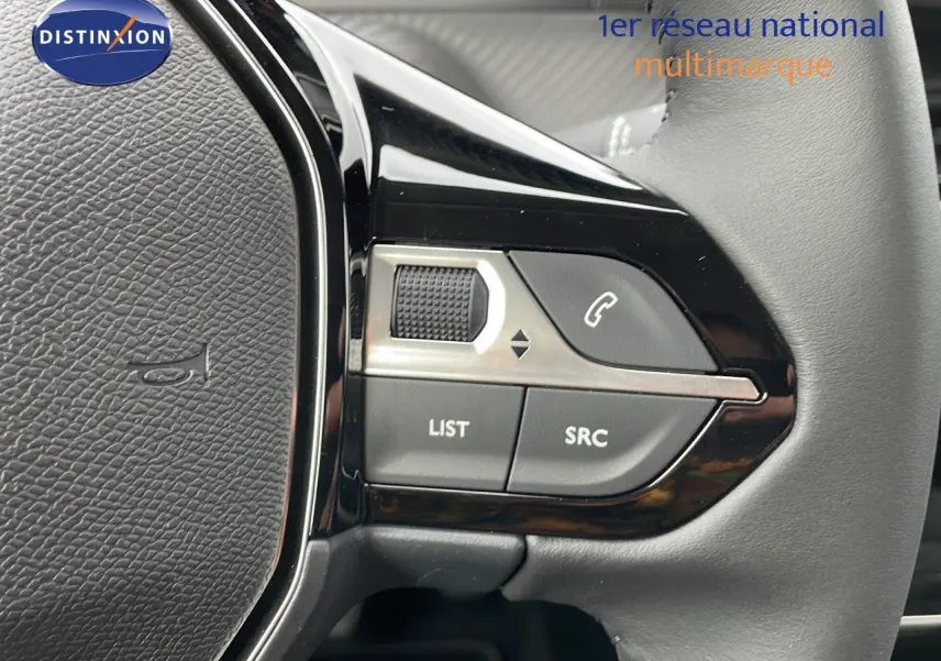 Gros plan sur les commandes gauche du volant en cuir gris d'une Peugeot 208 noire Perla Metal 2024.