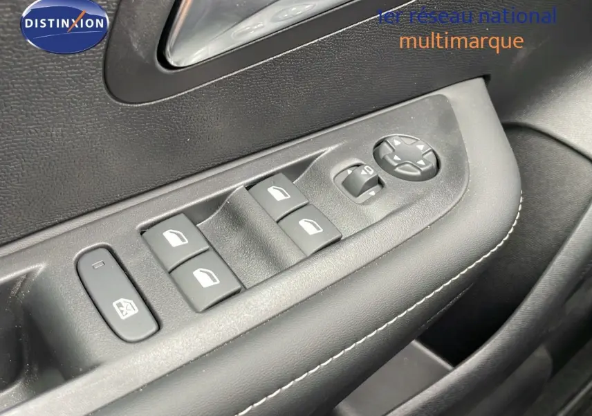 Gros plan sur les commandes de lève-vitres et réglage des rétroviseurs côté conducteur d'une Peugeot 208 noire.
