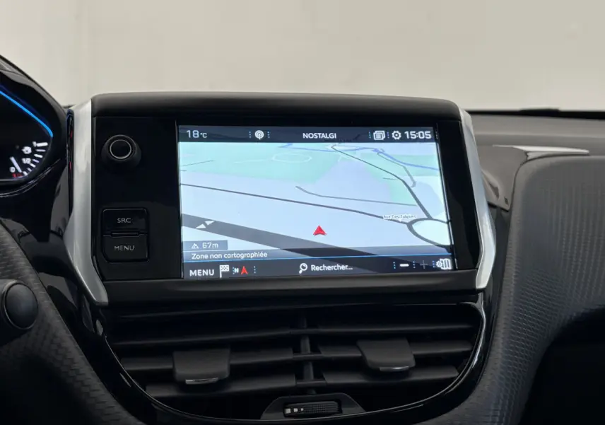 Écran tactile central du tableau de bord du Peugeot 2008 rouge, affichant la navigation GPS en intérieur.