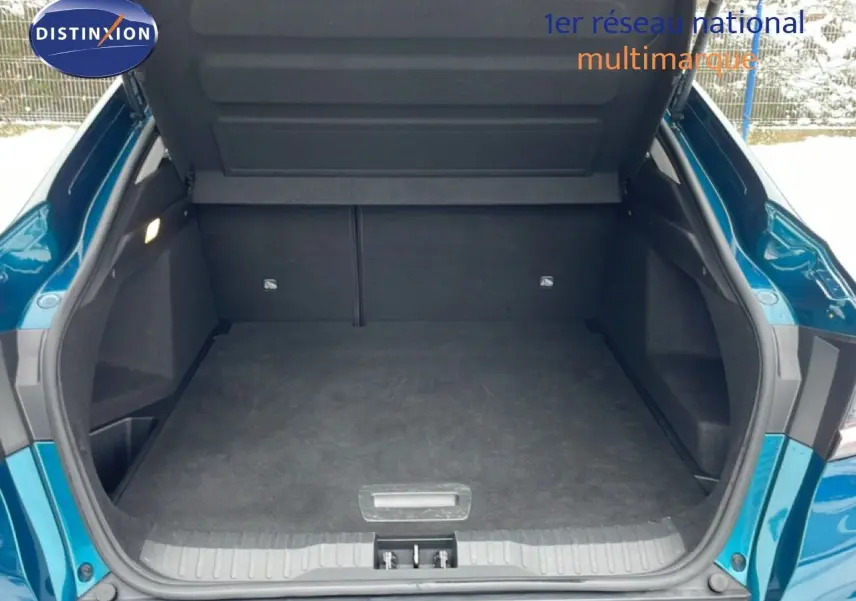 Coffre ouvert vu de l'arrière d'un Renault Arkana bleu Zanzibar métal, montrant l'espace de chargement vide.