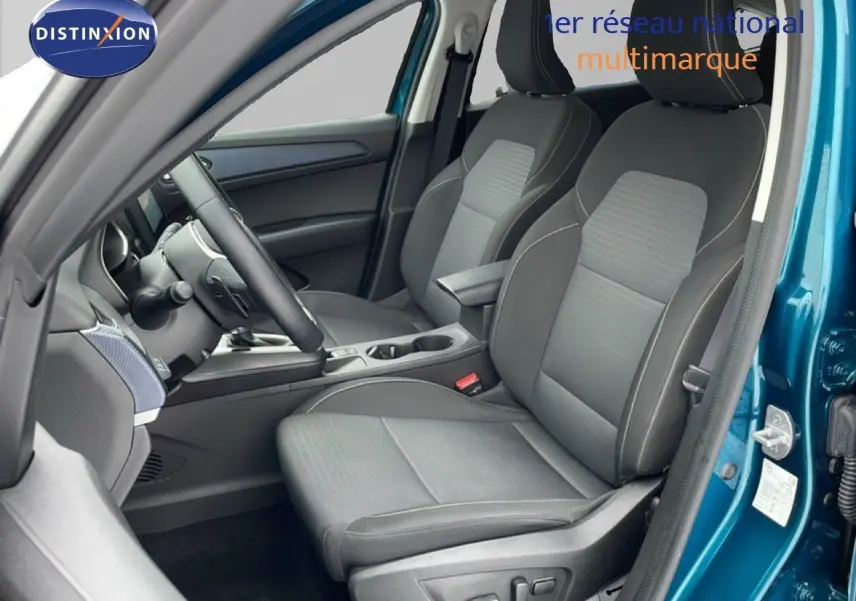 Vue intérieure côté conducteur du Renault Arkana bleu Zanzibar, mettant en valeur les sièges en tissu noir et la console centrale.