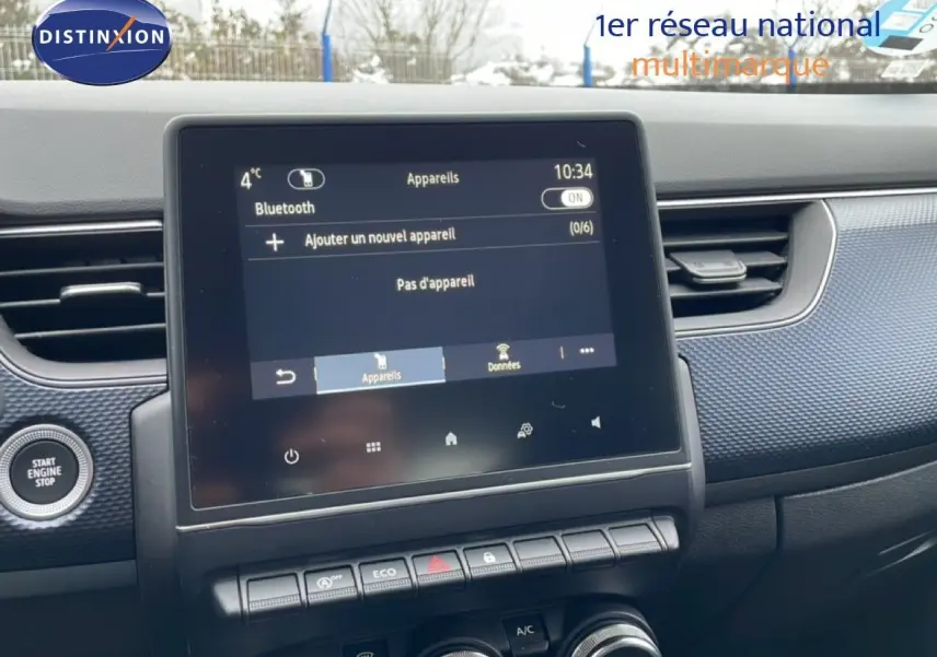 Vue intérieure centrée sur l'écran tactile et la console centrale du Renault Arkana bleu Zanzibar 2025.