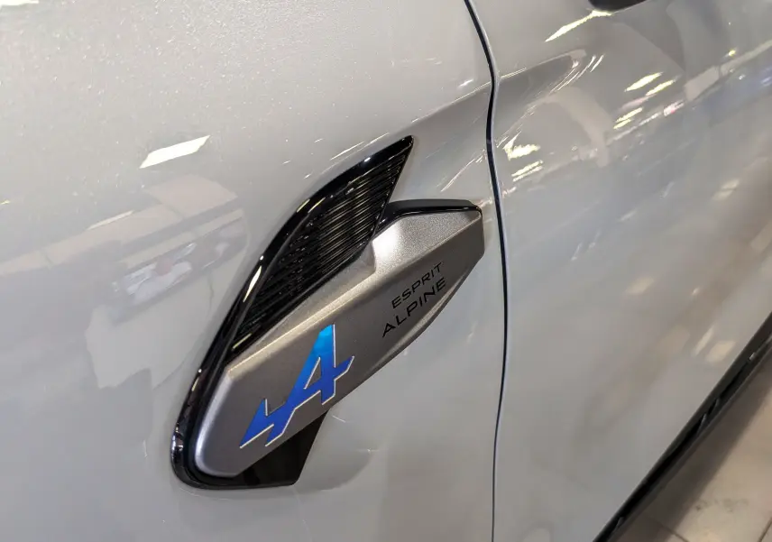Détail de l'aile avant gauche gris Rafale du Renault SYMBIOZ E-TECH avec logo Alpine bleu et noir.