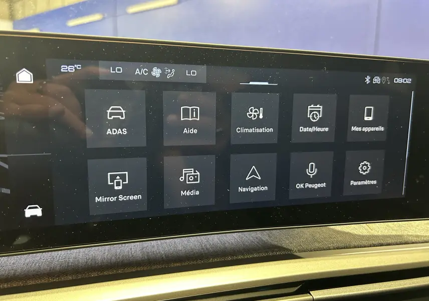 Écran tactile central du Peugeot 3008 III Hybrid avec menu affichant climatisation, navigation et aides à la conduite.