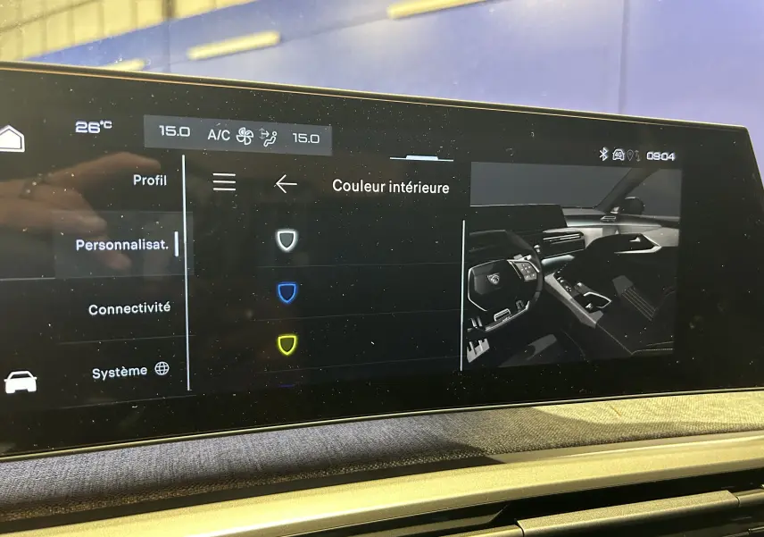 Écran tactile intérieur du Peugeot 3008 Hybrid 2026 affichant les options de couleur intérieure avec vue partielle du tableau de bord.