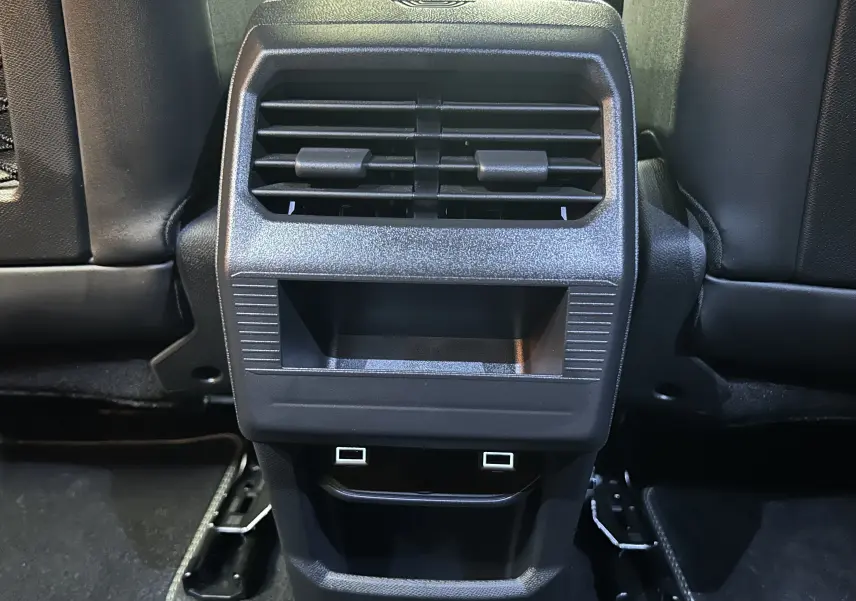 Vue rapprochée de la console arrière noire avec bouches d’aération et ports USB du Peugeot 3008 gris Artense.
