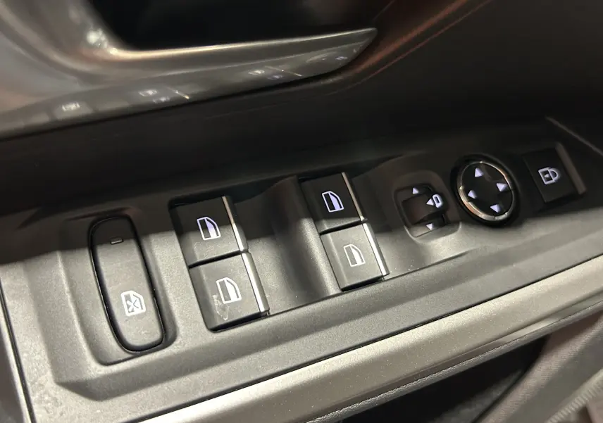Gros plan sur les commandes de lève-vitres et rétroviseurs côté conducteur du Peugeot 3008 gris Artense.