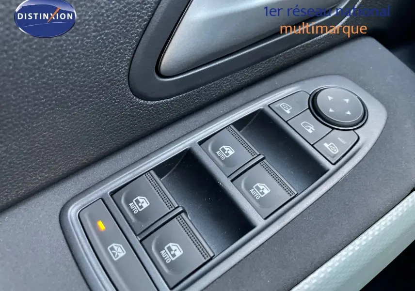 Gros plan sur les commandes des vitres électriques côté gauche d'un Dacia Duster noir métal 2024.