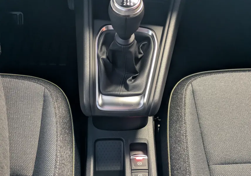 Vue rapprochée de la console centrale du Renault Captur 2025 avec levier de vitesse manuel et sièges tissu gris.