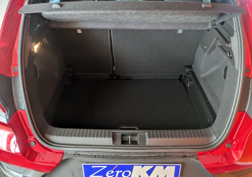 Coffre ouvert vu de l'arrière d'un Renault Captur rouge Désir 2025 avec intérieur noir et hayon relevé.