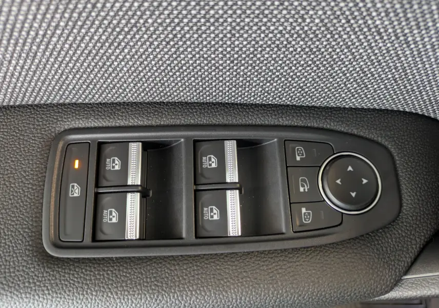 Panneau de commandes des vitres électriques et rétroviseurs côté gauche intérieur d’un Renault Captur rouge Désir 2025.