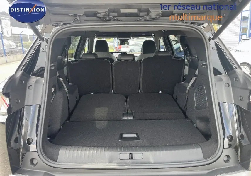 Coffre ouvert du Peugeot 5008 noir perle métal, vue arrière montrant les sièges arrière rabattus et l'espace de chargement.