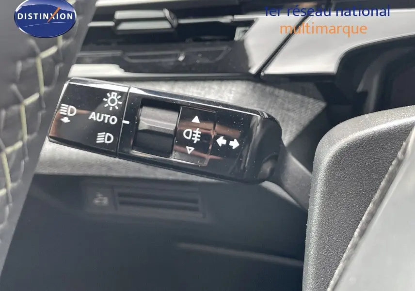 Gros plan sur le commodo des feux du Peugeot 5008 noir perle métal, montrant les commandes d'éclairage automatique et antibrouillard.