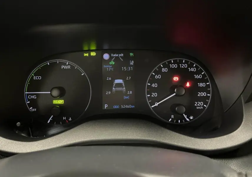 Tableau de bord de Mazda2 hybride 2023 montrant compteurs analogiques, écran central avec pression pneus et voyants allumés.